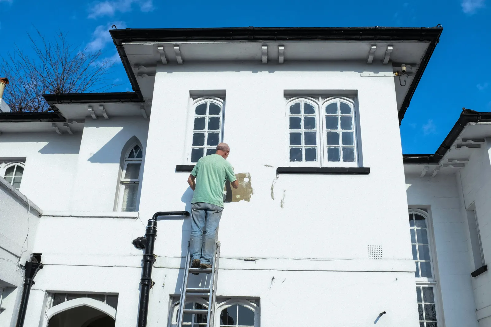 Maler beim Anstrich einer Hausfassade
